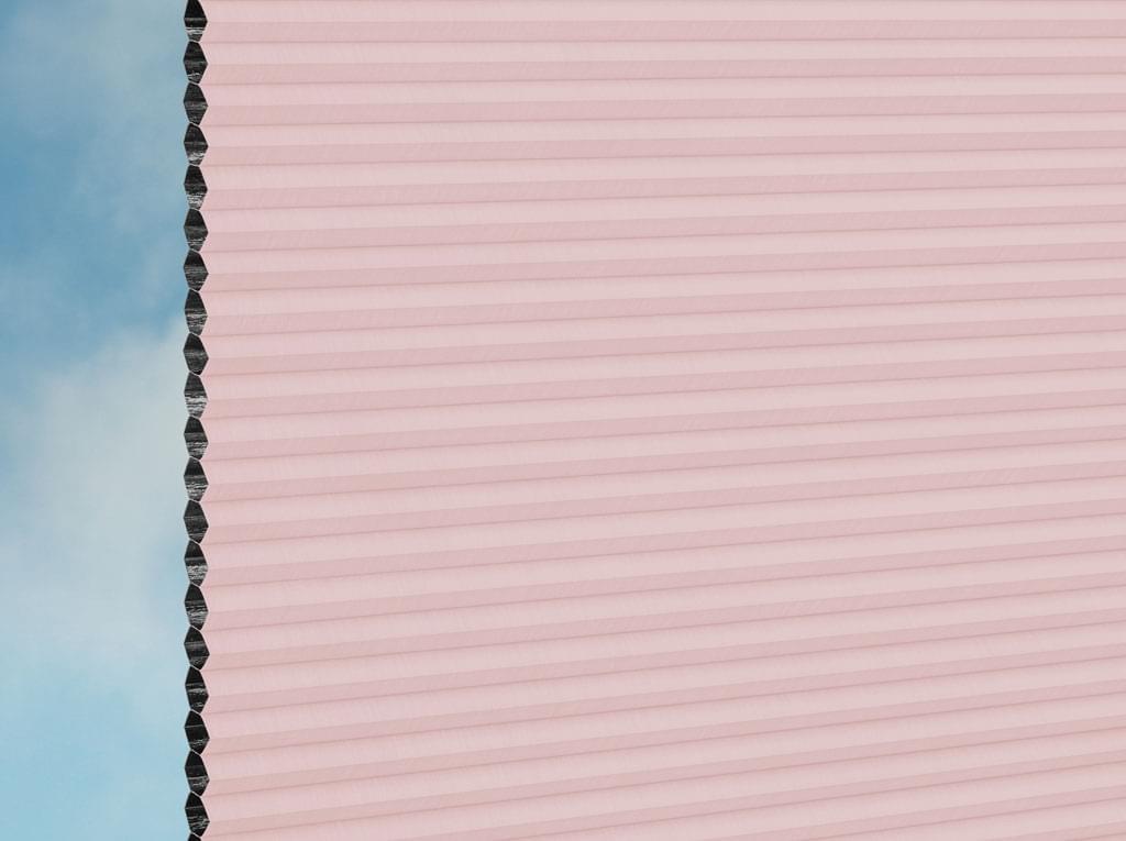 Nahaufnahme einer DUETTE® Fixé Elan Dark (4.3795) Rosa von Duetteshop, die ihre hellrosa Wabenstruktur von der Seite vor einem zartblauen und weißen Hintergrund zeigt.